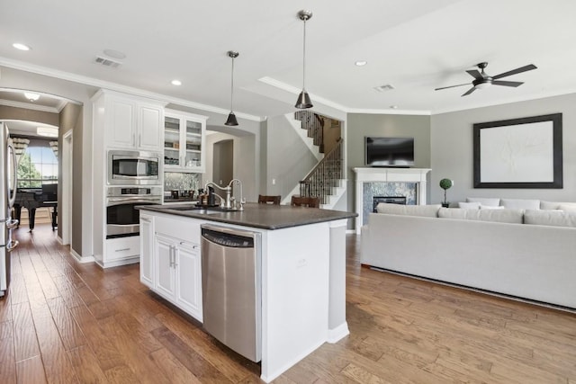 2717 Highland Trl, Leander, TX 78641 - kitchen featuring stainless steel appliances, arched walkways, dark countertops, crown molding, and open floor plan