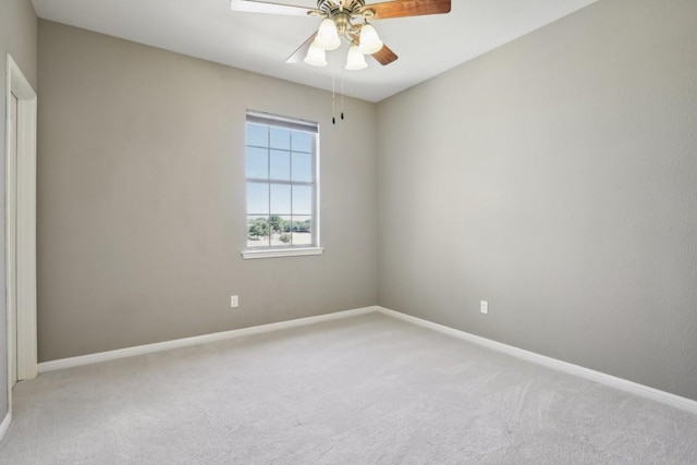 empty room featuring light carpet, a ceiling fan, and baseboards