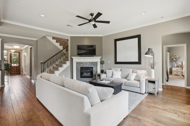 2717 Highland Trl, Leander, TX 78641 - living area with arched walkways, a ceiling fan, wood-type flooring, stairway, and baseboards