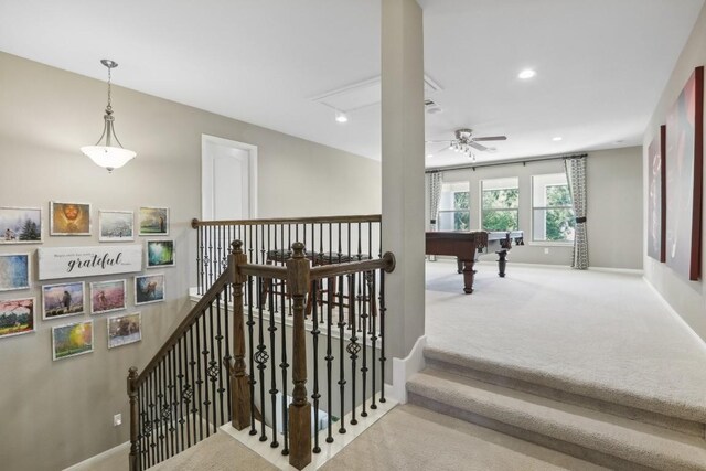 staircase with billiards, ceiling fan, and carpet flooring