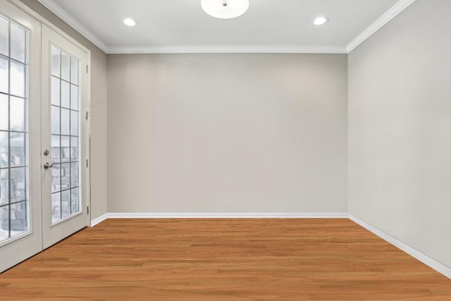 empty room featuring crown molding, french doors, light wood-style floors, recessed lighting, and baseboards