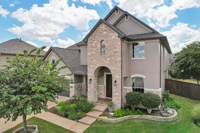 view of front of home with stone siding, stucco siding, and roof with shingles