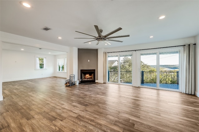 unfurnished living room with hardwood / wood-style flooring, a wealth of natural light, and ceiling fan