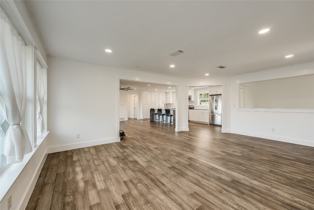 unfurnished living room featuring wood-type flooring and ceiling fan