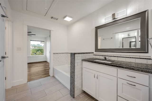 bathroom with hardwood / wood-style flooring, a bathing tub, and vanity