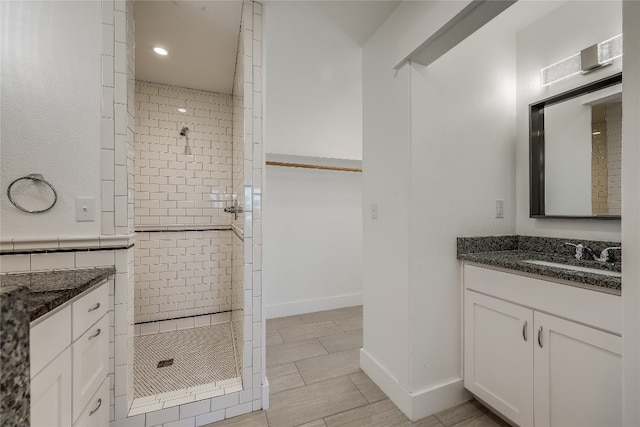 bathroom featuring tiled shower and vanity