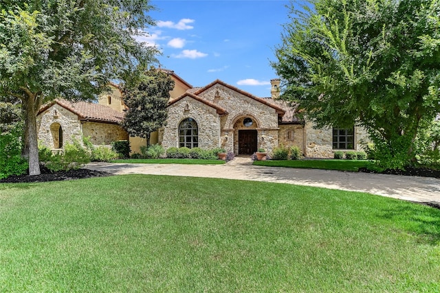 mediterranean / spanish house with a front yard