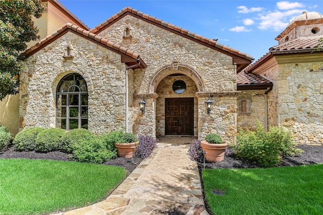 entrance to property featuring a lawn