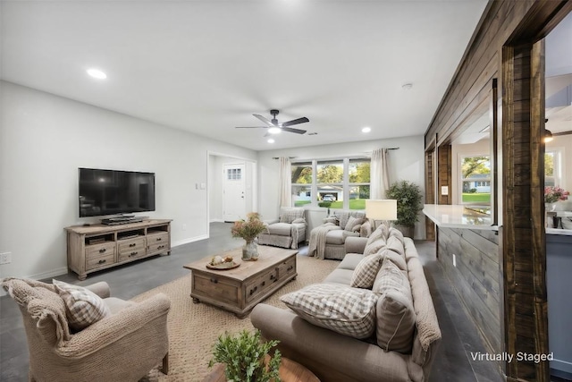 living room with ceiling fan and concrete floors