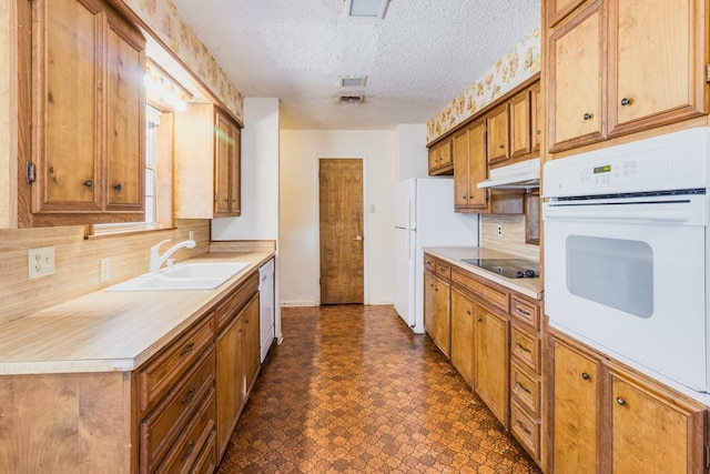 kitchen with backsplash, white appliances, a textured ceiling, and sink