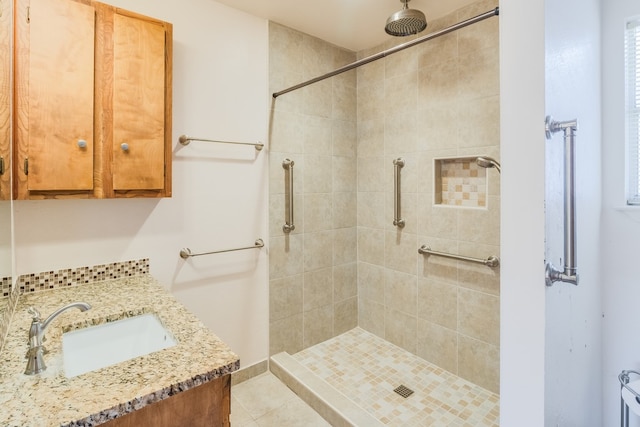 bathroom featuring tiled shower, vanity, and tile patterned floors