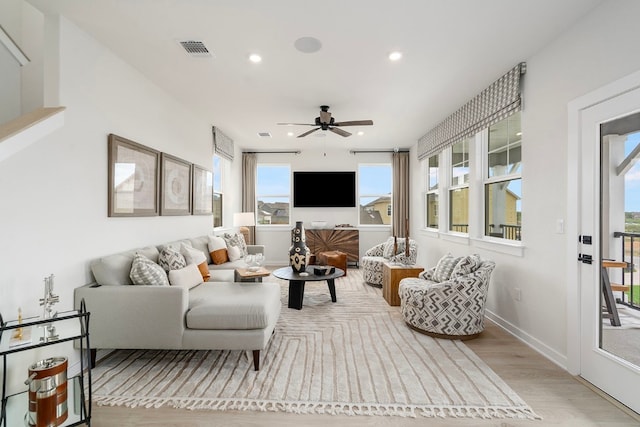 living room featuring plenty of natural light, ceiling fan, and light hardwood / wood-style floors