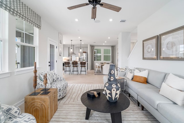 living room featuring ceiling fan and light wood-type flooring