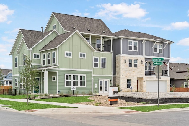 view of front of house featuring a balcony, a front yard, and a garage