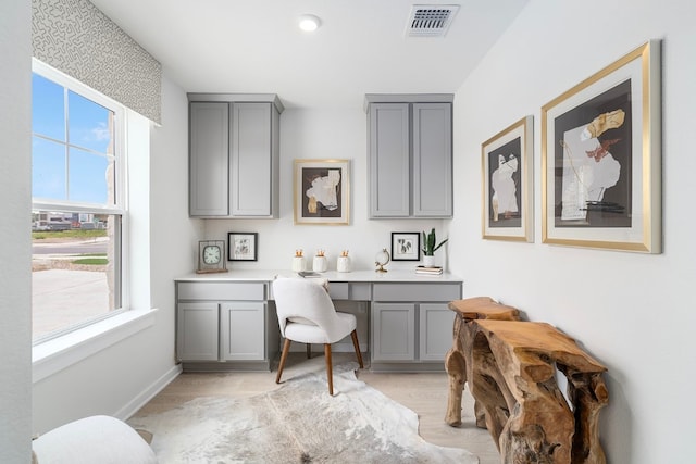 office featuring built in desk and light hardwood / wood-style flooring