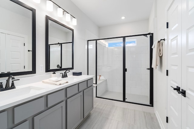 bathroom featuring vanity and a shower with door