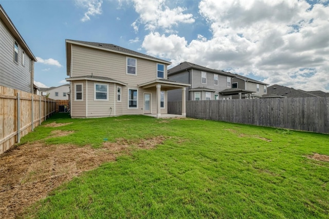 rear view of property featuring a lawn and a patio