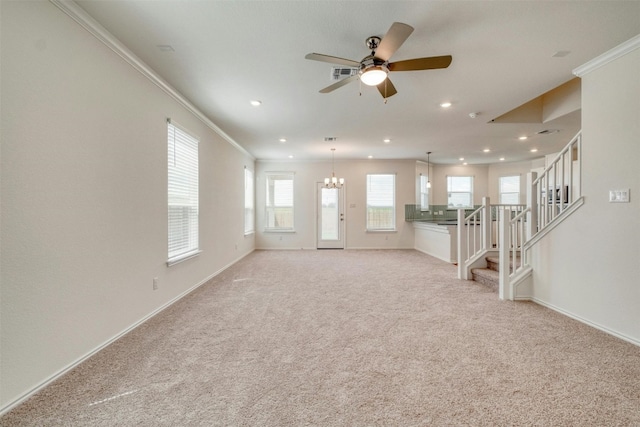 unfurnished living room featuring crown molding, light carpet, and ceiling fan with notable chandelier