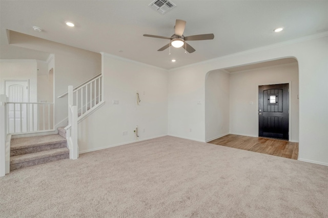 unfurnished living room with ceiling fan, light colored carpet, and ornamental molding