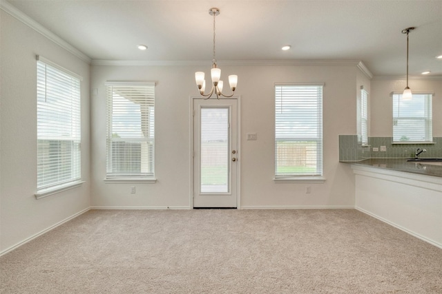 interior space with sink, light colored carpet, crown molding, and a chandelier