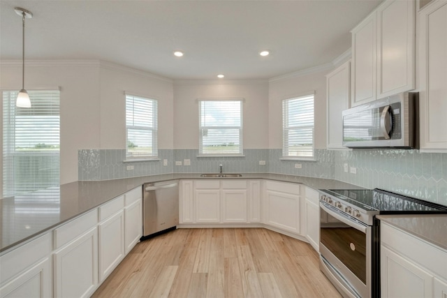 kitchen featuring decorative backsplash, appliances with stainless steel finishes, sink, light hardwood / wood-style flooring, and white cabinetry