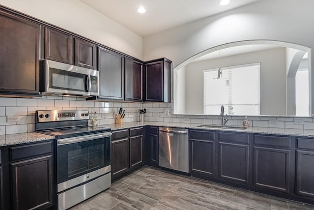 kitchen with hardwood / wood-style floors, stainless steel appliances, dark brown cabinets, and sink