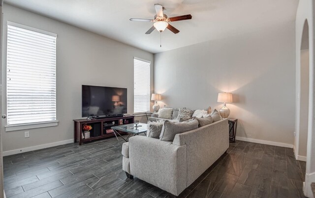 living room with a wealth of natural light, ceiling fan, and dark hardwood / wood-style floors