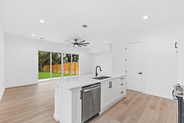 kitchen with appliances with stainless steel finishes, a kitchen island with sink, sink, white cabinetry, and ceiling fan