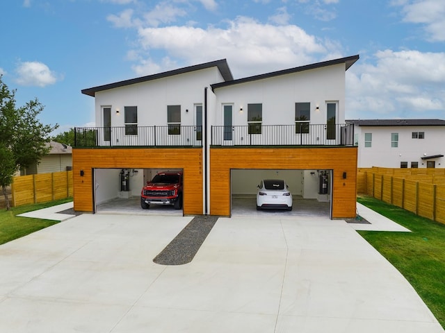 rear view of house with a balcony, a garage, and a yard