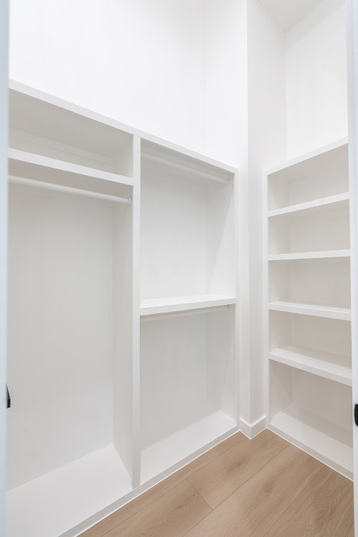 walk in closet with hardwood / wood-style floors