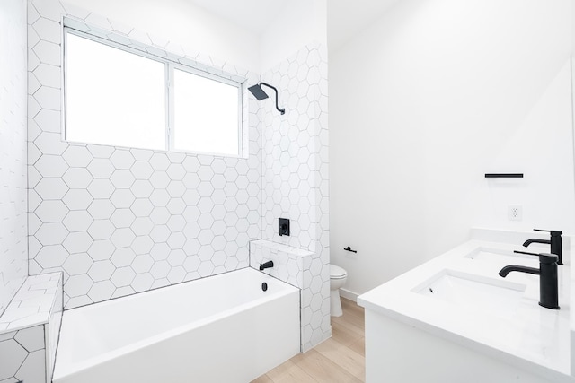 full bathroom featuring vanity, toilet, hardwood / wood-style flooring, and tiled shower / bath