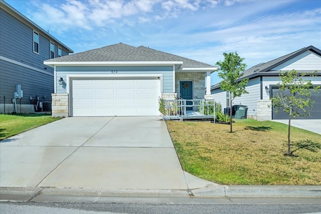 view of front of home with a garage, a front lawn, and central AC