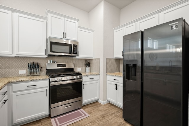 kitchen featuring white cabinets, appliances with stainless steel finishes, and light hardwood / wood-style flooring