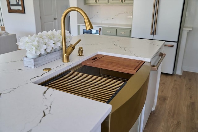 room details featuring light stone countertops, white fridge, and light hardwood / wood-style flooring