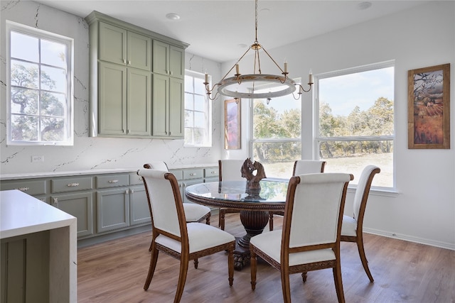 dining area with light hardwood / wood-style flooring and a notable chandelier