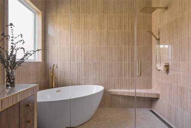 bathroom with plus walk in shower, tile patterned floors, and tile walls