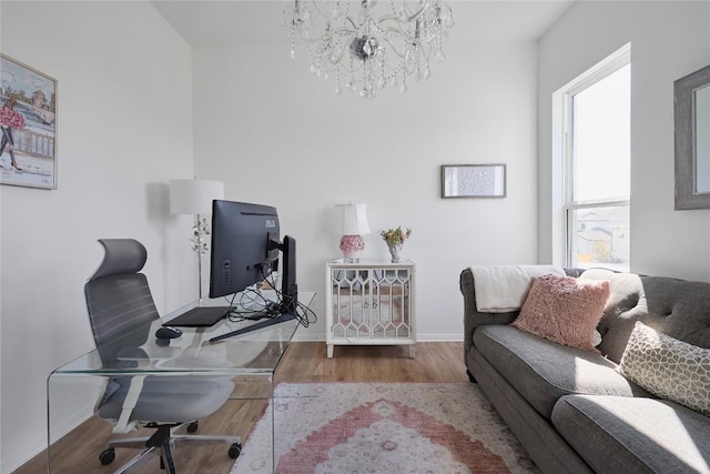 office area featuring wood-type flooring and an inviting chandelier