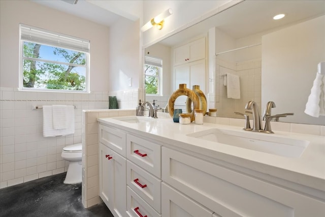 bathroom featuring vanity, toilet, and tile walls