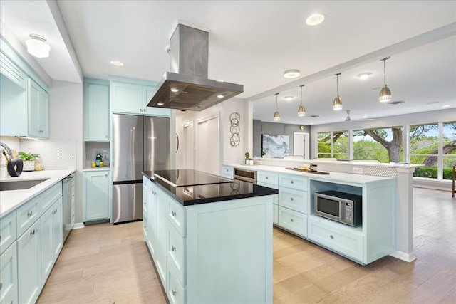 kitchen with a center island, sink, tasteful backsplash, island exhaust hood, and stainless steel appliances