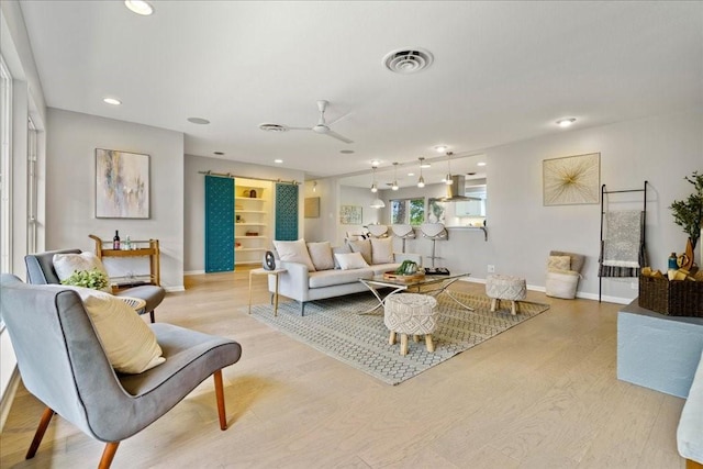 living room featuring ceiling fan and light wood-type flooring