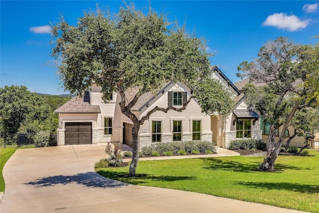french country inspired facade with stucco siding, driveway, a front lawn, and stone siding