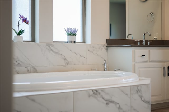 bathroom featuring a bath, a wealth of natural light, and vanity