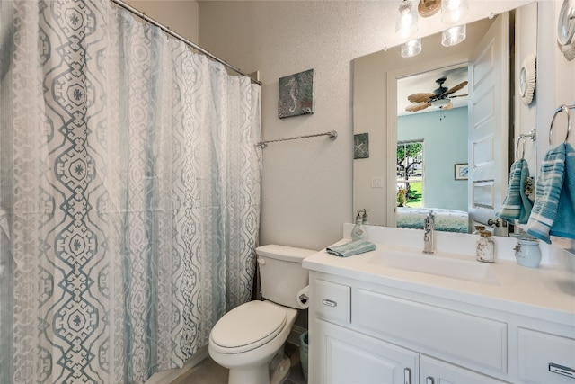 bathroom with vanity, toilet, walk in shower, and ceiling fan