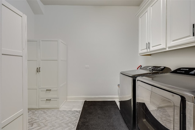 laundry room featuring cabinets and washing machine and clothes dryer