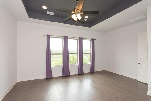 19108 Excursion Falls Way, Jonestown, TX 78645 - spare room with a tray ceiling, visible vents, dark wood-style flooring, and ceiling fan