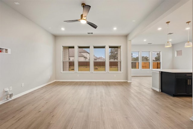 unfurnished living room featuring light hardwood / wood-style flooring and ceiling fan