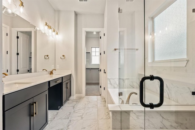 bathroom featuring vanity and a relaxing tiled tub