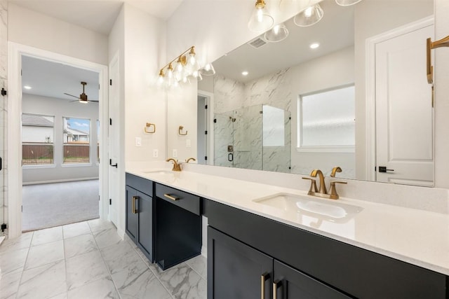 bathroom featuring ceiling fan, a shower with shower door, and vanity