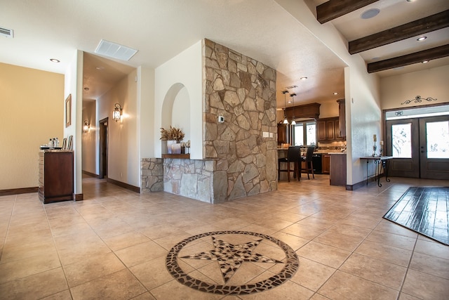 tiled entryway featuring beamed ceiling and a healthy amount of sunlight