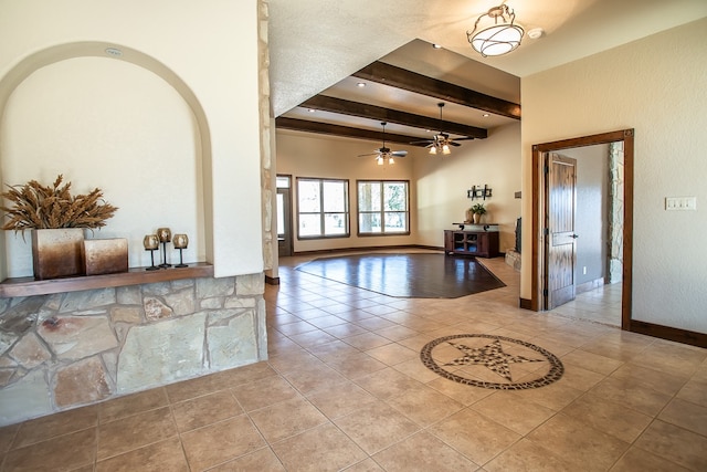 tiled foyer with ceiling fan, a tray ceiling, and beam ceiling